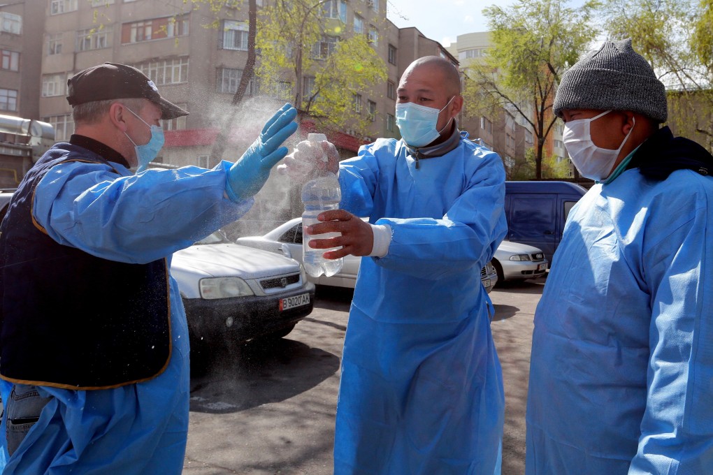 Volunteers spray disinfectant on each other as they deliver humanitarian aid to poor and large families Bishkek, Kyrgyzstan. The country has declared a state of emergency after the outbreak of Covid-19. Photo: EPA-EFE