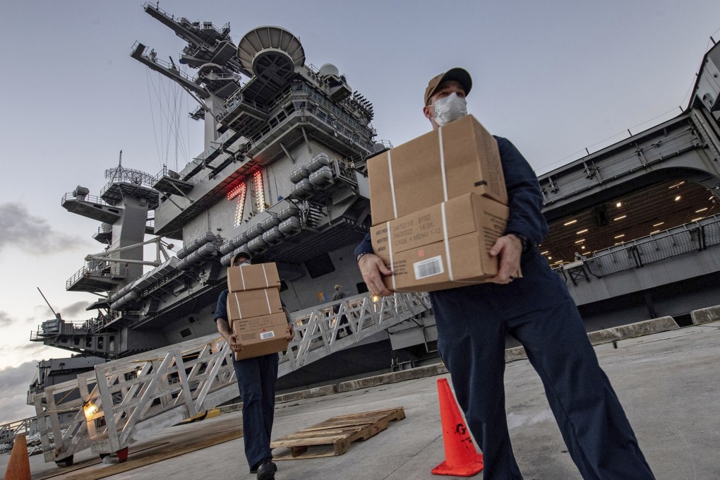 Sailors assigned to the aircraft carrier USS Theodore Roosevelt move ready to eat meals for crew members who have tested negative for Covid-19 and are being taken to local hotels at Naval Base Guam. Photo: US Navy via AP