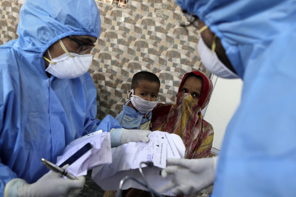 Doctors check people for coronavirus symptoms in a slum area of Mumbai during India’s nationwide lockdown. Photo: AP