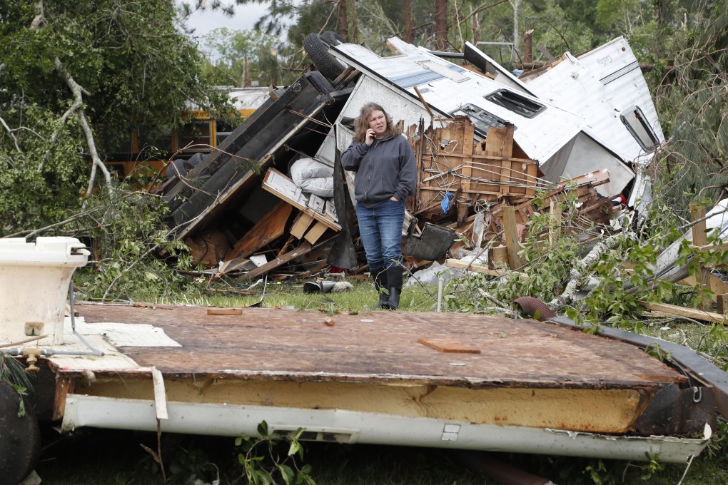 Elaine Powell speaks with relatives on her mobile phone as she surveys the remains of her boyfriend's property in Carson, Mississippi, on Monday. Photo: AP