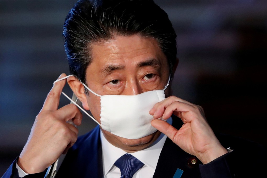 Japan's Prime Minister Shinzo Abe adjusts his face mask as he arrives to speak to the media in Tokyo earlier this month. Photo: Reuters