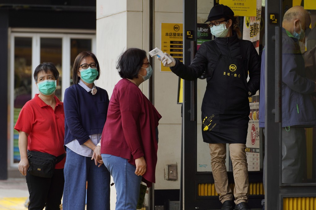 Customers have their temperatures checked at a restaurant in Hong Kong during the coronavirus pandemic. Photo: AP