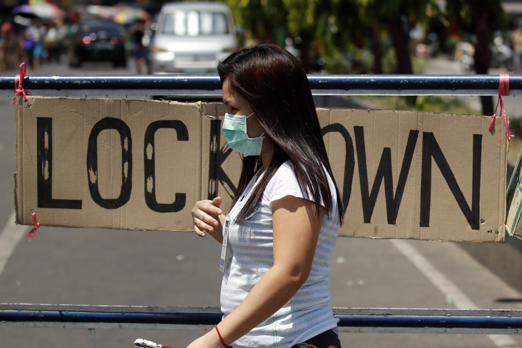 A resident of Manila walks past a lockdown sign on April 7. Photo: EPA