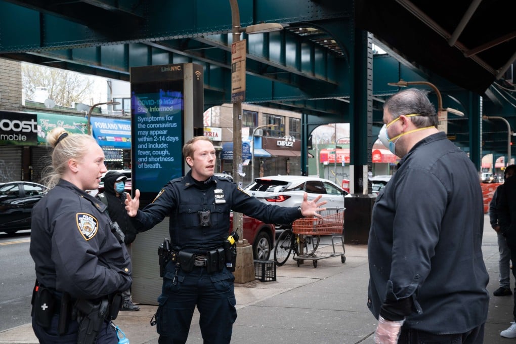 Police officers enforce social distancing as dozens of people stand in line outside of Seatide Fish & Lobster market in Queens, New York on April 10. Photo: Getty Images via AFP