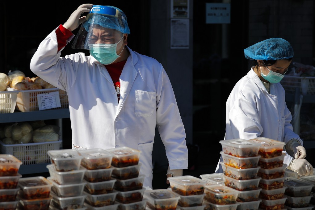 Workers prepare food orders outside a restaurant only offering takeaway business in Beijing. Photo: AP