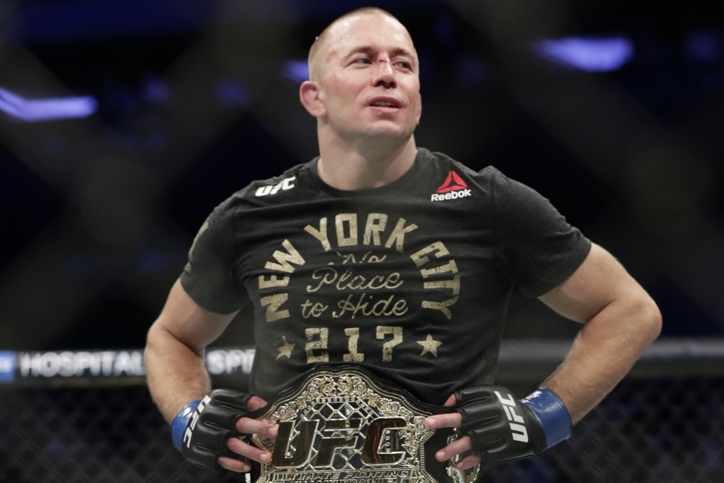 Georges St-Pierre celebrates after claiming the middleweight title from Michael Bisping at UFC 217. Photo: AP
