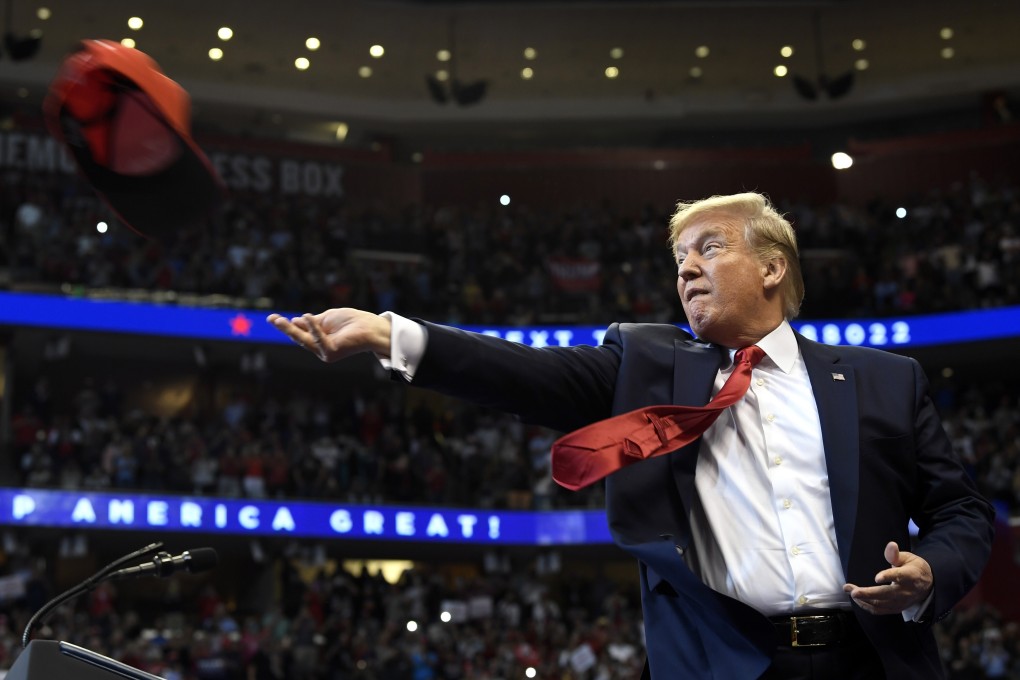 US President Donald Trump throws a hat as he arrives at a campaign rally in Sunrise, Florida, on November 26 last year. Photo: AP
