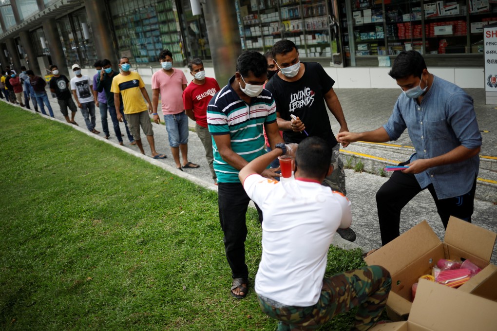 Volunteers distribute free meals to migrant workers in Singapore. Photo: Reuters