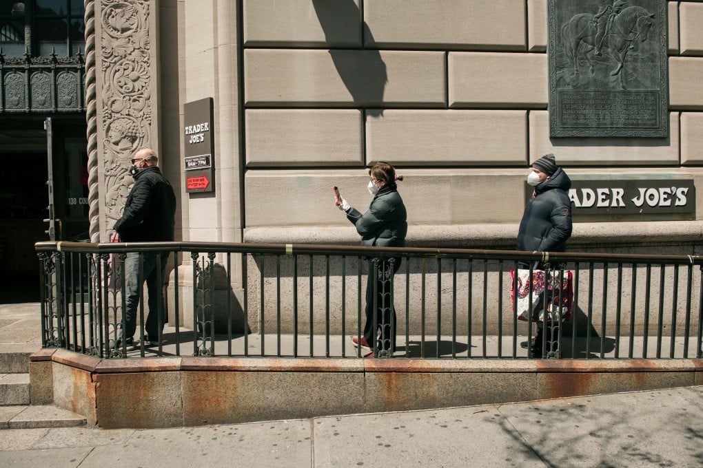 Supermarket shoppers in New York stand apart from each other amid calls to practise social distancing. Photo: AFP