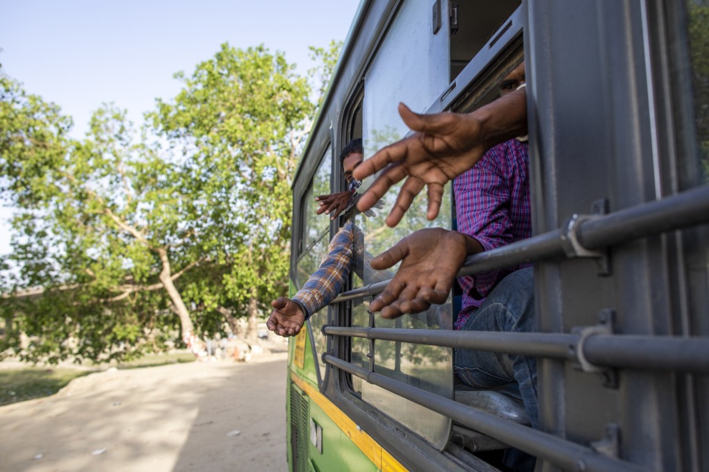 People being transferred to a shelter in New Delhi during India’s coronavirus lockdown gesture for food that was being distributed on Wednesday. Photo: Bloomberg