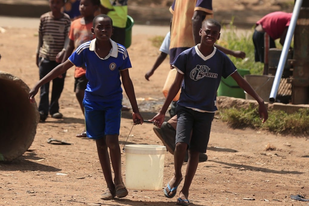 Children fetch water from a bore hole in a suburb in Harare, Zimbabwe. Photo: Xinhua