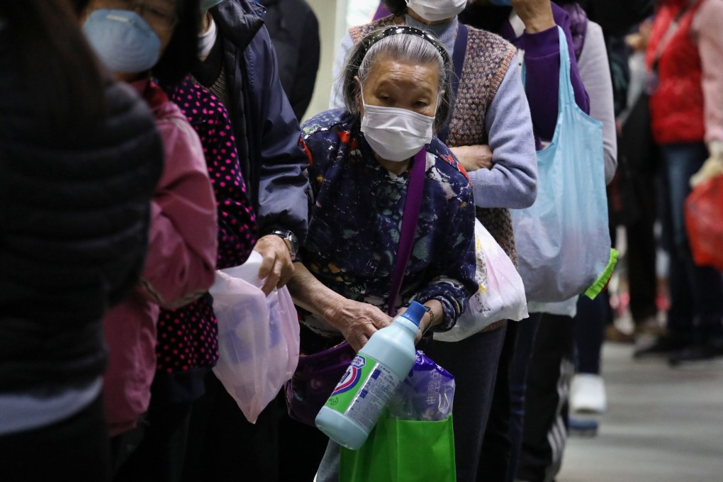 Elderly residents line up to collect 500ml of free bleach being distributed in Kowloon Bay on February 16. Photo: Nora Tam