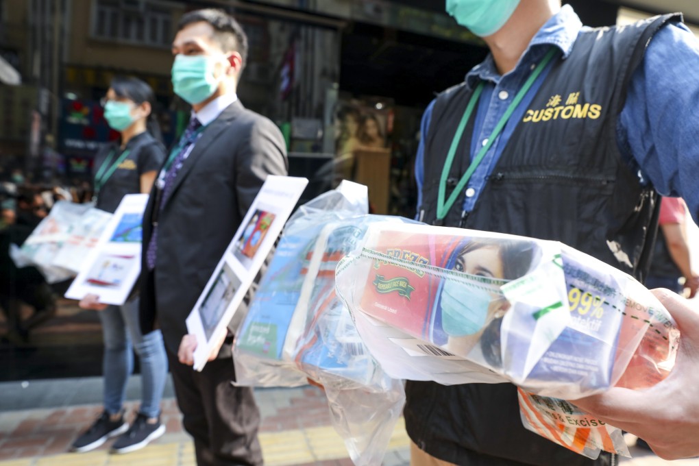 Hong Kong customs officers display the tainted face masks seized during a routine inspection. Photo: Nora Tam