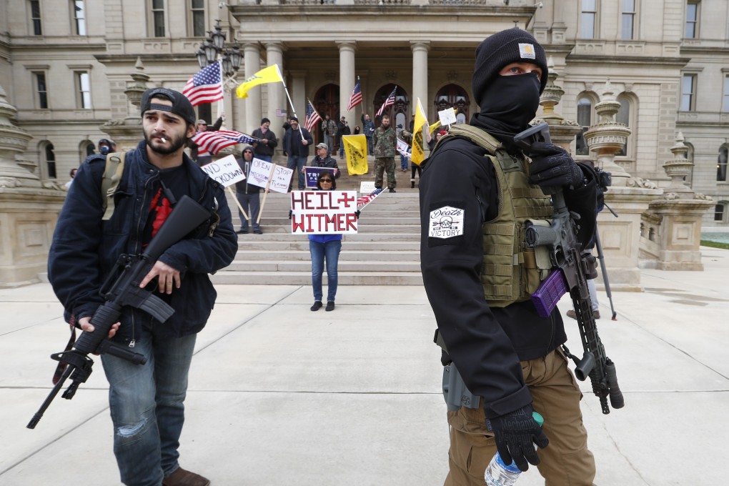 Protesters carry rifles near the steps of the Michigan State Capitol building in Lansing, Michigan, on Wednesday. Photo: AP