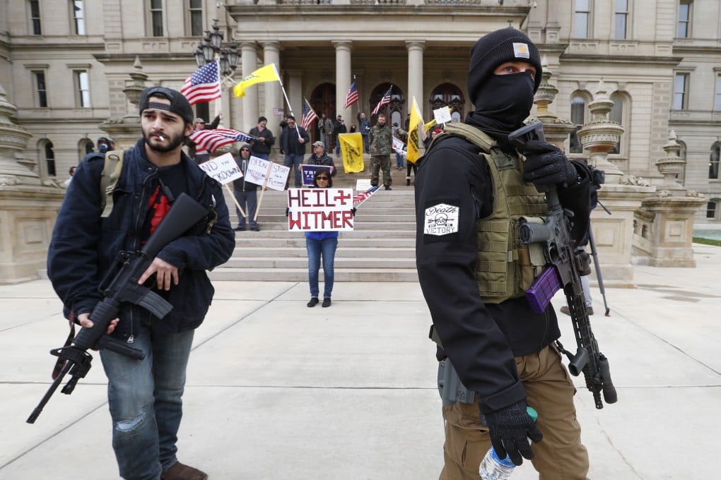 Protesters carry rifles near the steps of the Michigan State Capitol building in Lansing, Michigan, on Wednesday. Photo: AP