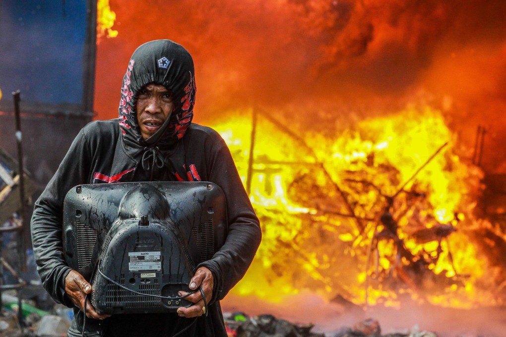 A resident salvages some belongings from a fire in Manila on April 18, 2020. Photo: Xinhua