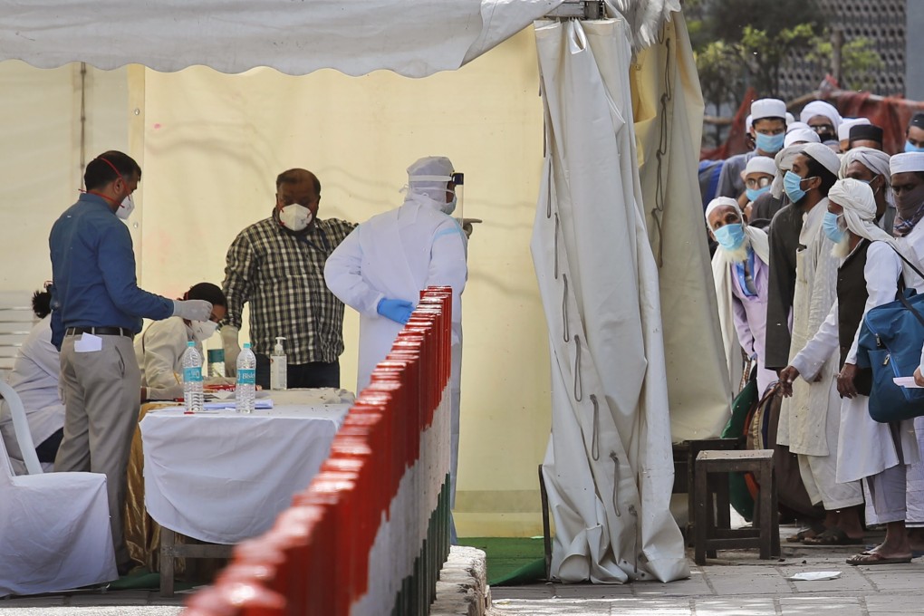 Indian paramedics note down the names of Muslim pilgrims before they are taken to a quarantine facility, amid concerns over the spread of Covid-19, in the Nizamuddin area of New Delhi. Photo: AP
