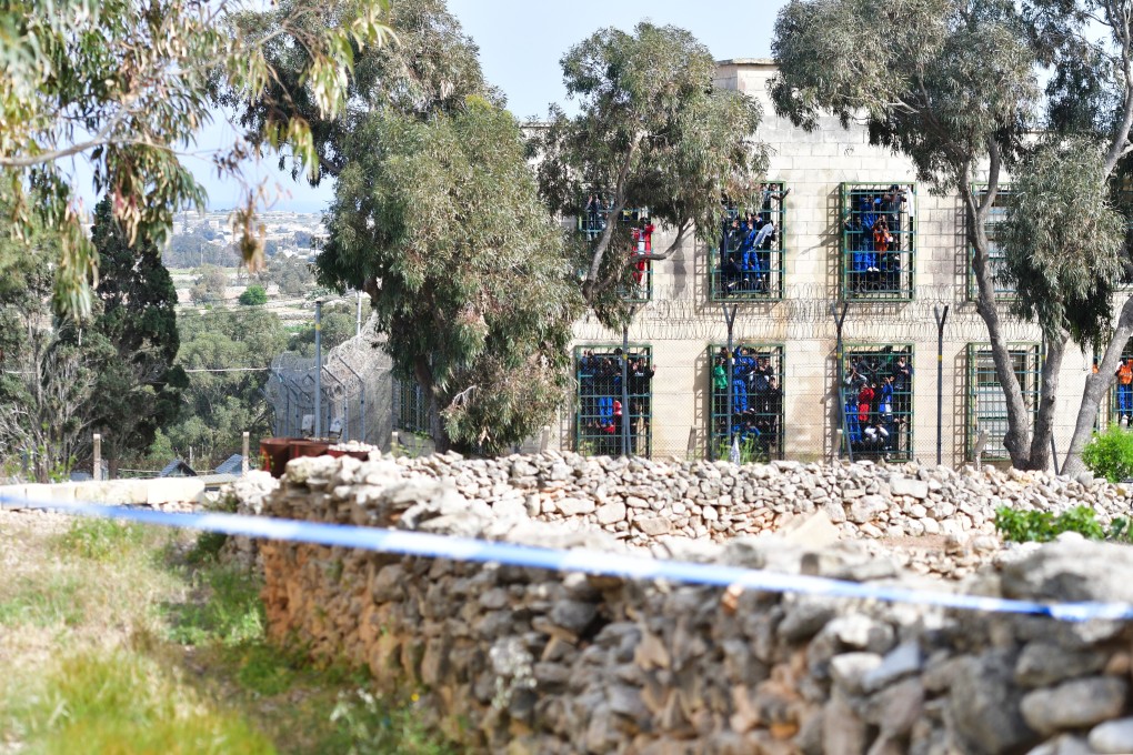 Migrants chant slogans at their windows during a protest at the Hal Far detention centre in Birzebbuga, Malta. Photo: Xinhua