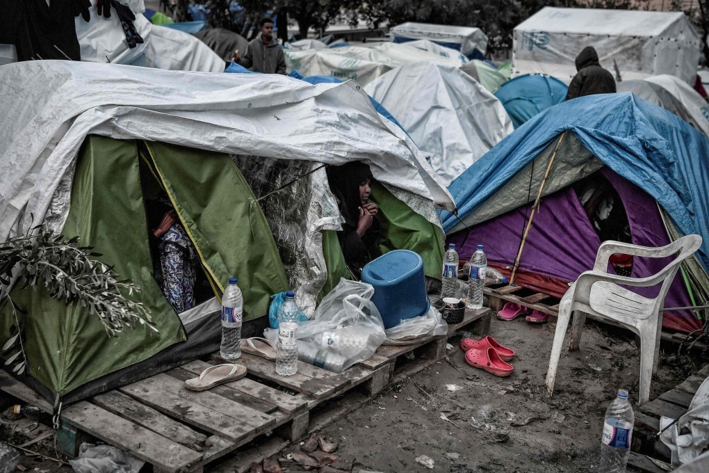 A woman sits at the door of a tent in the Vial camp on the island of Chios. Photo: AFP
