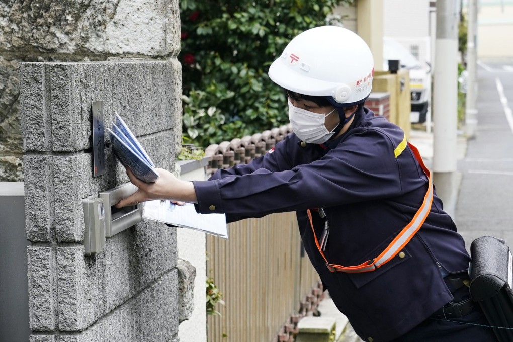 A postal worker delivers free cloth masks to a house in Tokyo on Friday under the controversial government programme. Photo: Kyodo