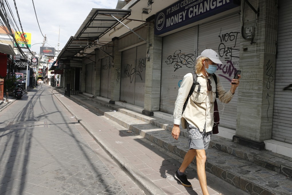 A tourist walks along a road lined with closed shops in Bali, Indonesia, on April 14. Photo: AP