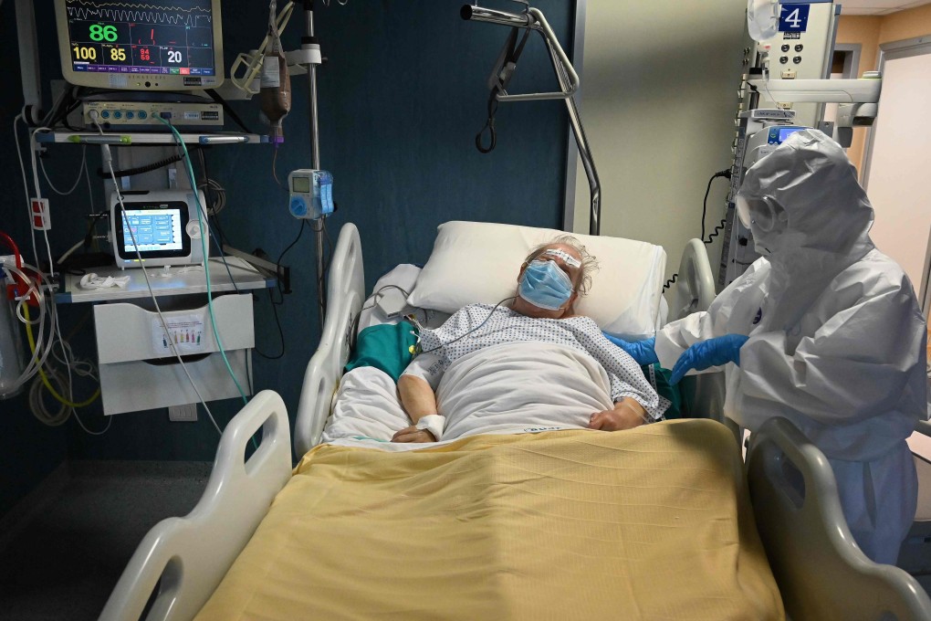 A health worker wearing protective gear takes care of a coronavirus patient. Photo: AFP