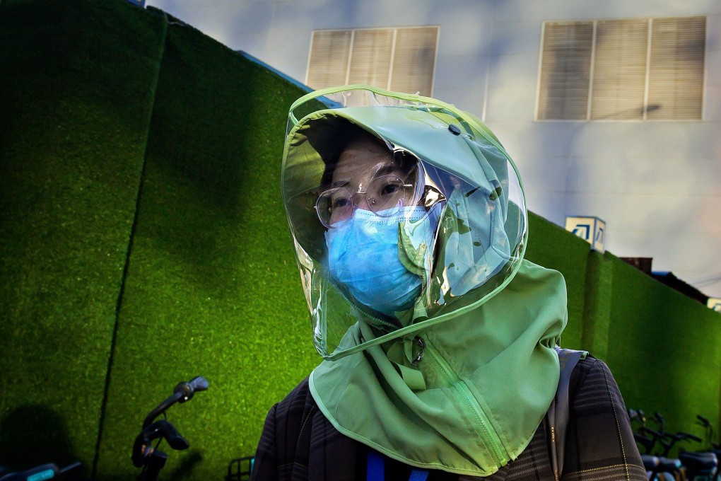 A woman wears a face mask and shield on a street in Beijing, China. Photo: AFP