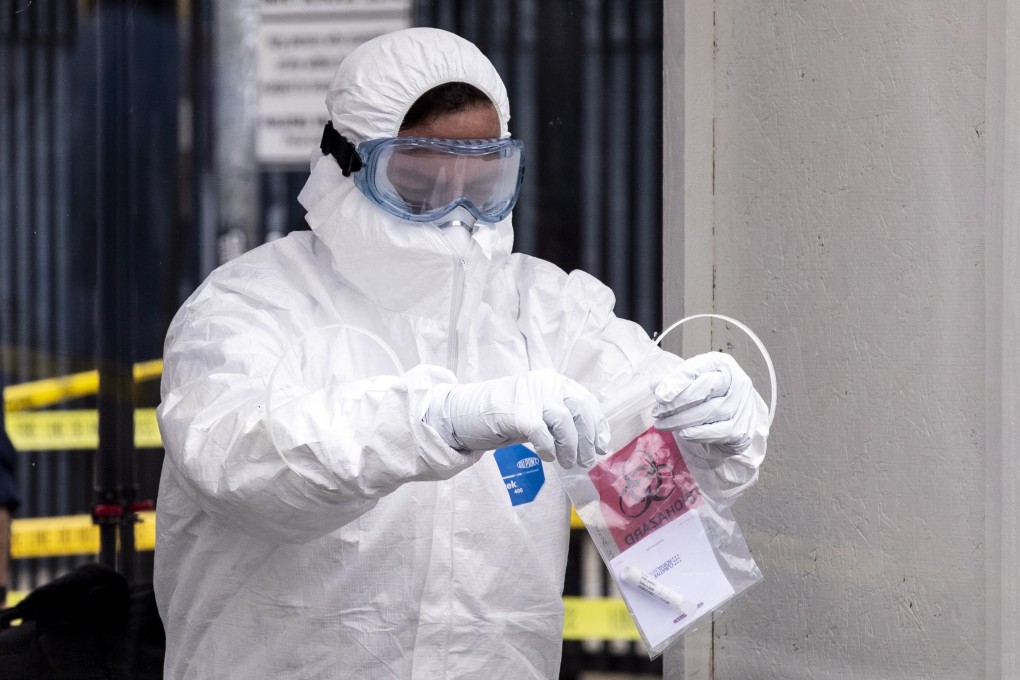 A worker in protective equipment bags a sample at a coronavirus test site in Los Angeles on Monday. Photo: EPA-EFE