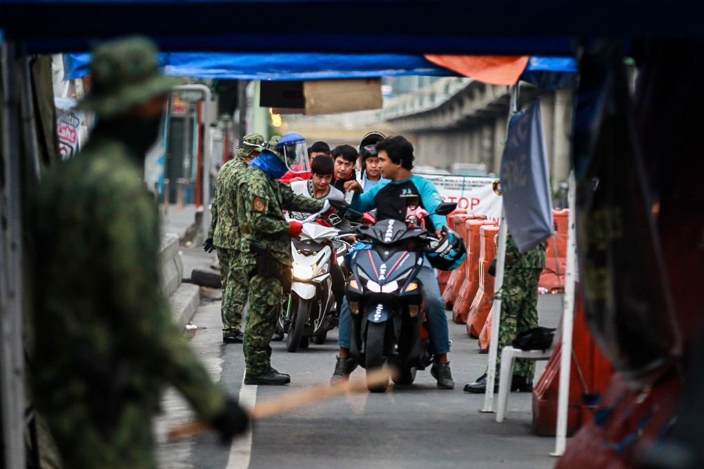 Philippine police dressed in camouflage stop motorcyclists at a checkpoint in Antipolo City earlier this month. Photo: Xinhua