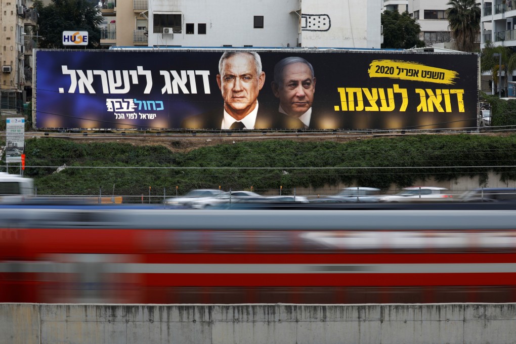 Traffic moves past a Blue and White party election campaign poster depicting party leader Benny Gantz, and Israeli Prime Minister Benjamin Netanyahu, in Tel Aviv, Israel in February. Photo: Reuters