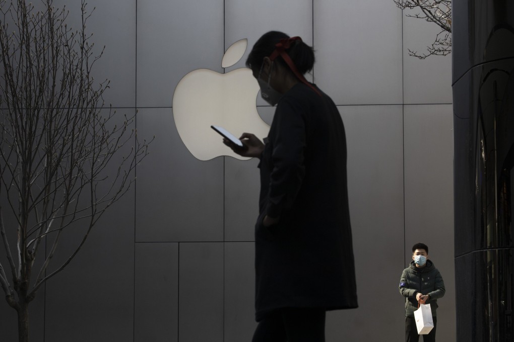 A woman uses her phone near the Apple store in Beijing in February. Photo: AP