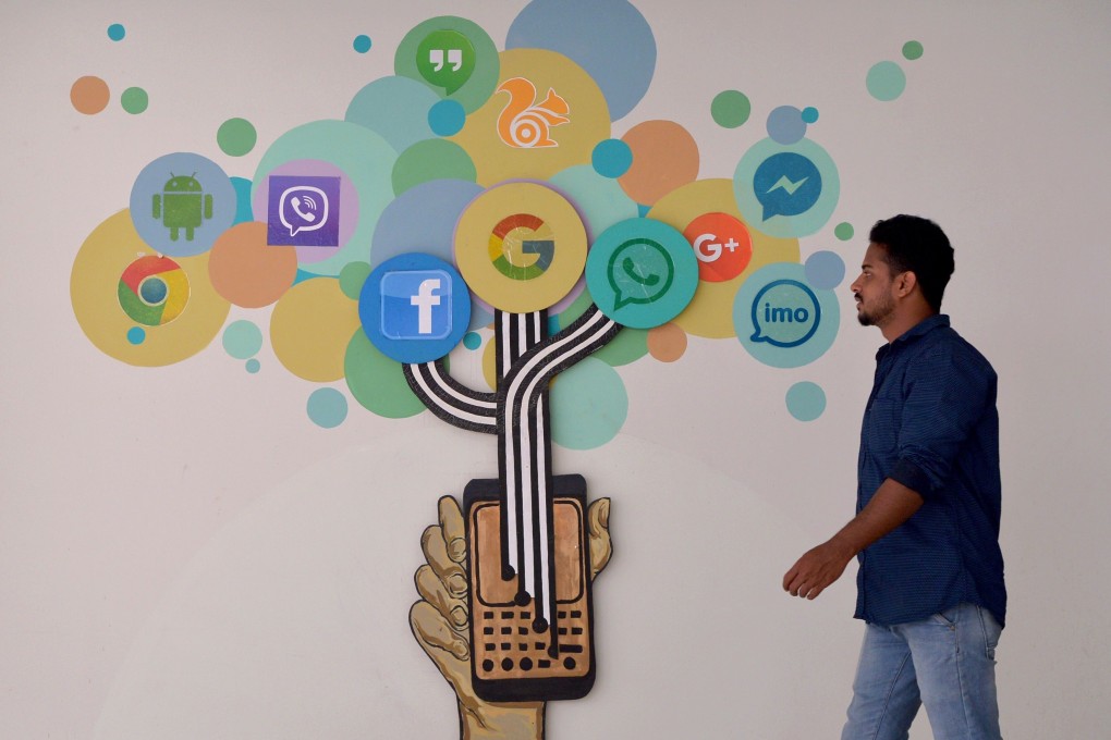 A visitor passes a mural depicting various social media sites logos, including Facebook, inside a building in Bangalore, India. Facebook’s US$5.7 billion stake in the Jio Platforms unit of Reliance Industries marks one of the biggest foreign investments in the country. Photo: Agence France-Presse
