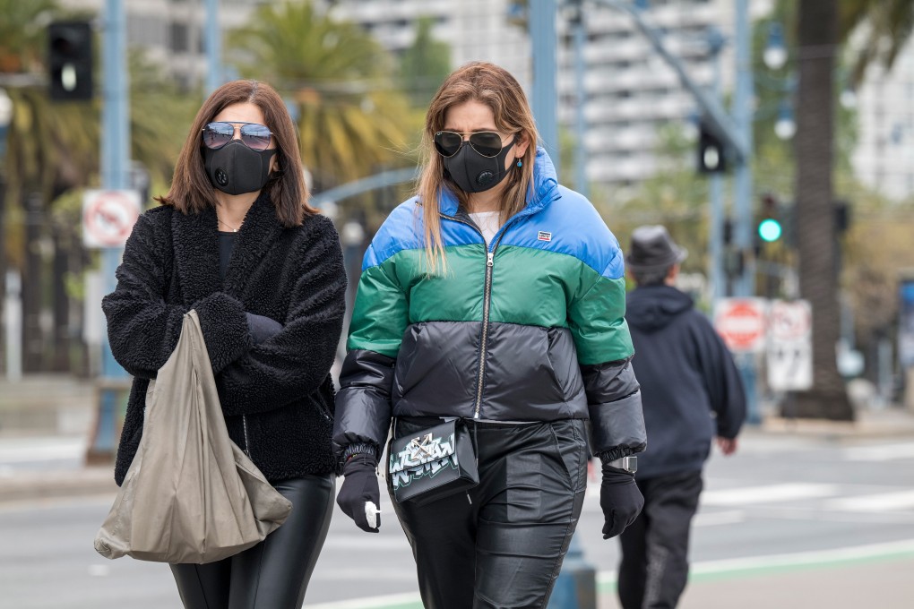 Pedestrians wearing protective masks walk on the Embarcadero in San Francisco, California, US, on Monday, April 20, 2020. Photo: Bloomberg