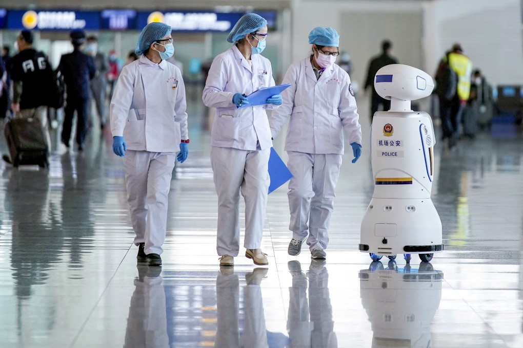 Medical workers look at a police robot at Wuhan Tianhe International Airport after travel restrictions on Wuhan, the epicentre of the Covid-19 pandemic, were lifted, on April 8, 2020. Photo: Reuters