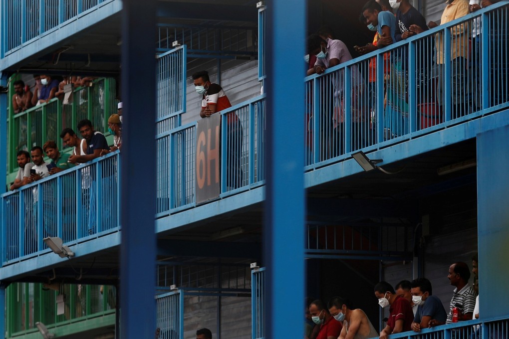 Migrant workers look out from their balconies at the Punggol S11 dormitory in Singapore on April 6. Photo: Reuters