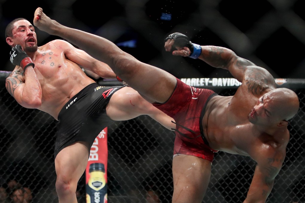 Robert Whittaker and Yoel Romero each attempt a kick in the fifth round of their middleweight title fight at UFC 225. Photo: AFP