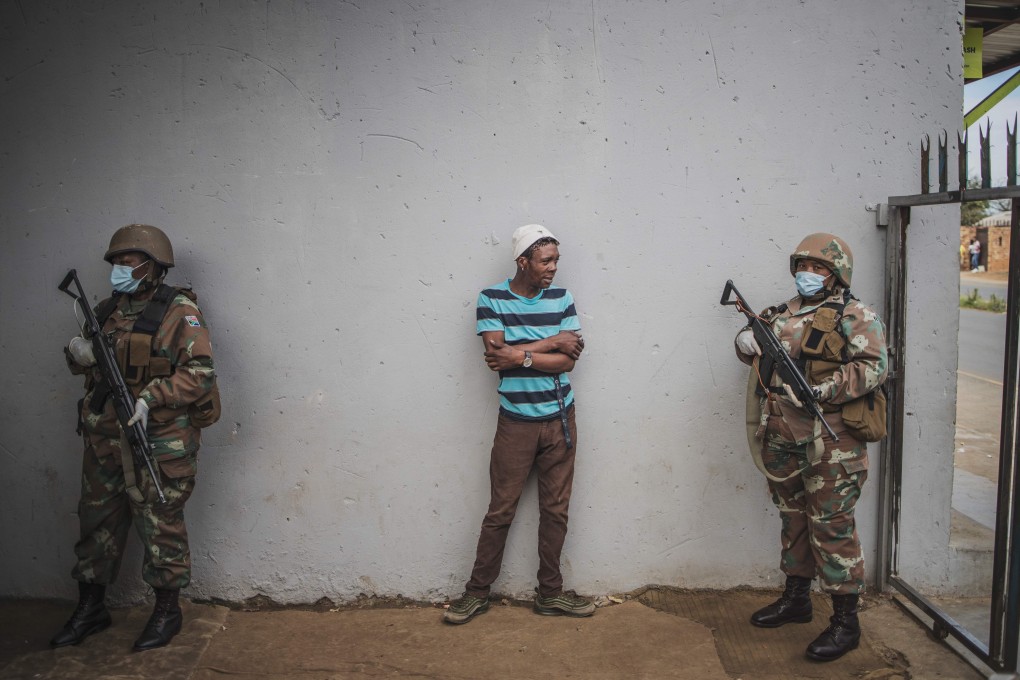 A man is questioned by a South African National Defence Force patrol after his corner shop was found open in Eldorado Park on March 30. South Africa came under a nationwide lockdown on March 27, joining other African countries imposing strict curfews and shutdowns in an attempt to halt the spread of Covid-19. Photo: AFP