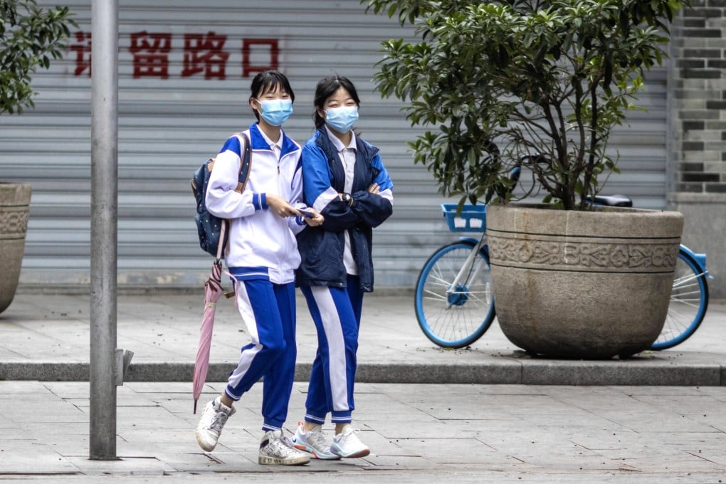 Students wear protective face masks while walking in Guangzhou, the capital of Guangdong, on Wednesday. Some schools in the city have started to resume. Photo: EPA-EFE