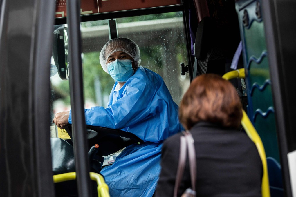 An air passenger boards a shuttle bus after leaving a temporary coronavirus testing centre set up for arriving passengers in Hong Kong. Photo: AFP