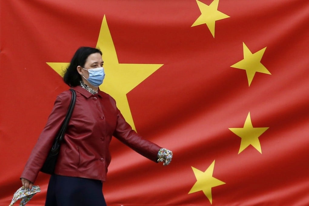 A woman wearing a face mask walks by a Chinese flag on a street in Belgrade, Serbia on April 13. Photo: AP