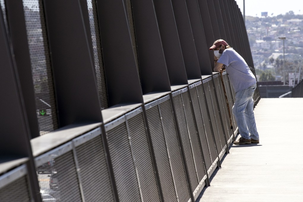 A man wearing a face mask looks at the US-Mexico border from a bridge in the district of San Ysidro in San Diego, California, on April 22. Rich countries can close their borders, but if the pandemic rages on in the poor, overpopulated countries, the virus will continue to circulate. Photo: EPA-EFE