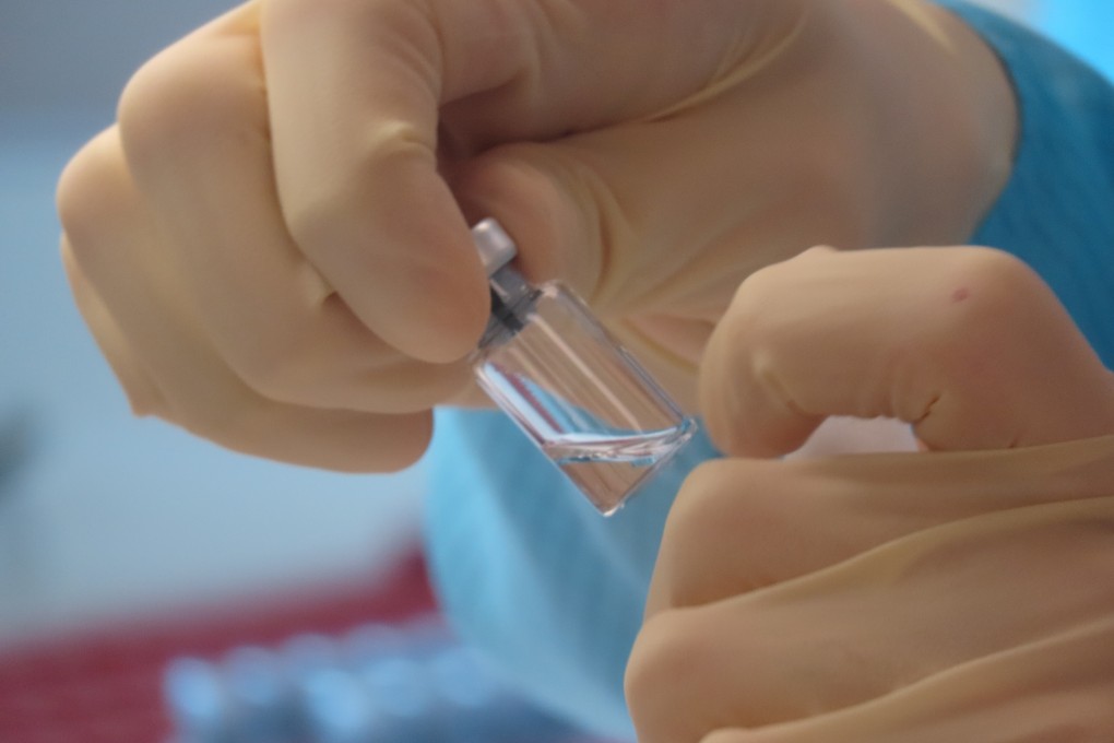 A scientist cleans vials at a vaccine laboratory in Oxford, England. Photo: Handout via Reuters