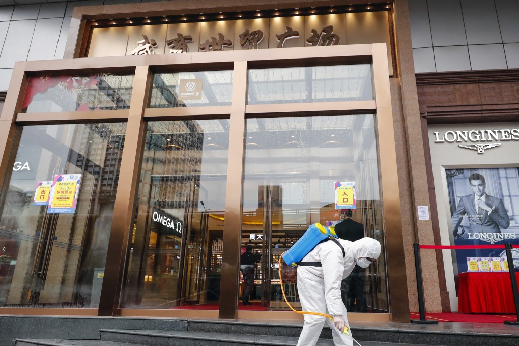 The entrance of a shopping centre in Wuhan is disinfected. Fashion designers in China who have physical stores are facing a dilemma: to move sales online, or hope for a pickup in physical sales. Photo: Xinhua
