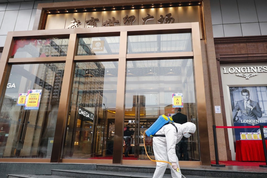 The entrance of a shopping centre in Wuhan is disinfected. Fashion designers in China who have physical stores are facing a dilemma: to move sales online, or hope for a pickup in physical sales. Photo: Xinhua