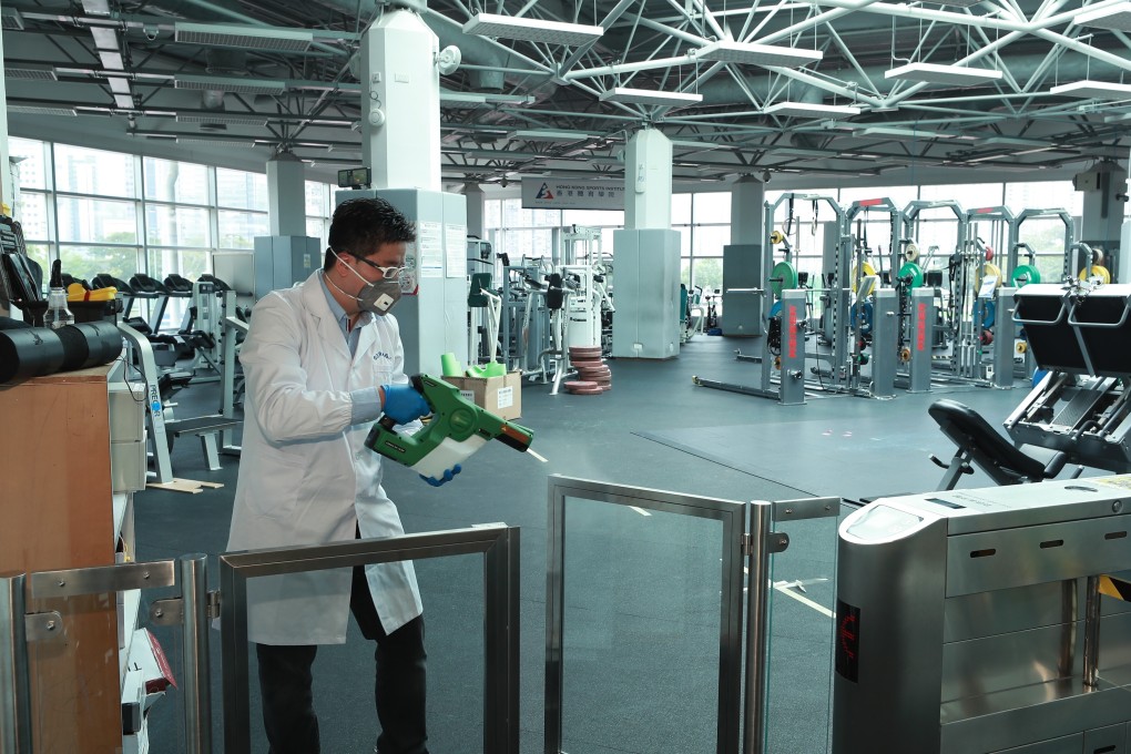 HKUST-CIL adviser Hamilton Hung sprays Germagic disinfectant on surfaces of the gym of the Hong Kong Sports Institute. Photo: Germagic