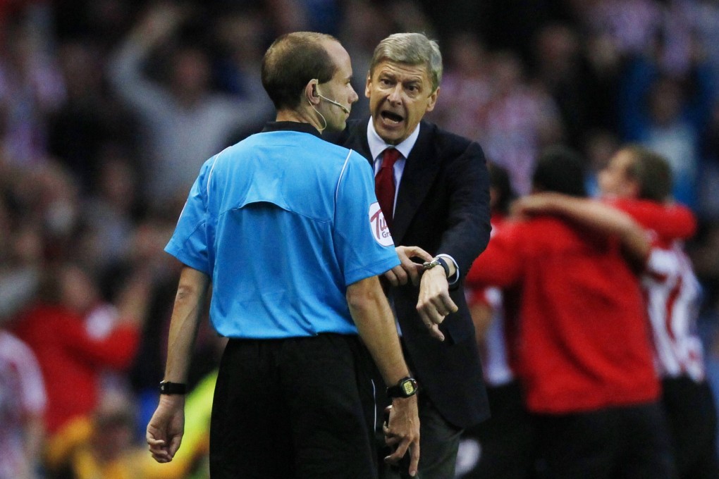 Arsenal head coach Arsene Wenger points to his watch to remonstrate a late Sunderland goal in 2010. Photo: Reuters