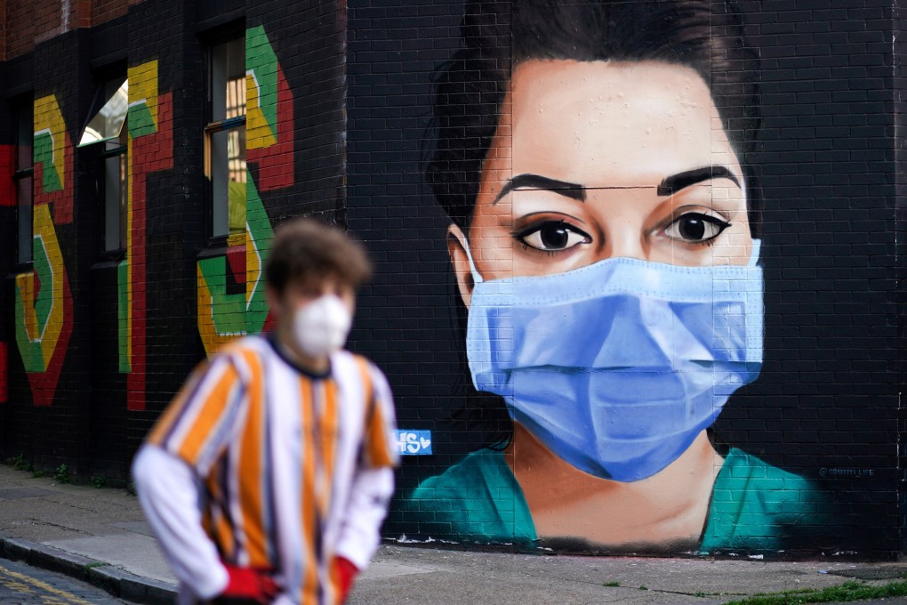 A man walks past a mural depicting a nurse in London, Britain, on April 21, 2020. Photo: Reuters