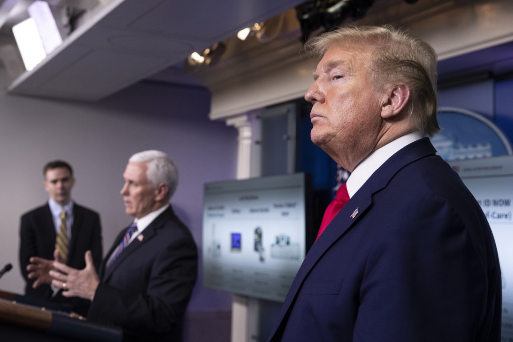 President Donald Trump stands as Vice-President Mike Pence speaks about the coronavirus. Photo: AP Photo