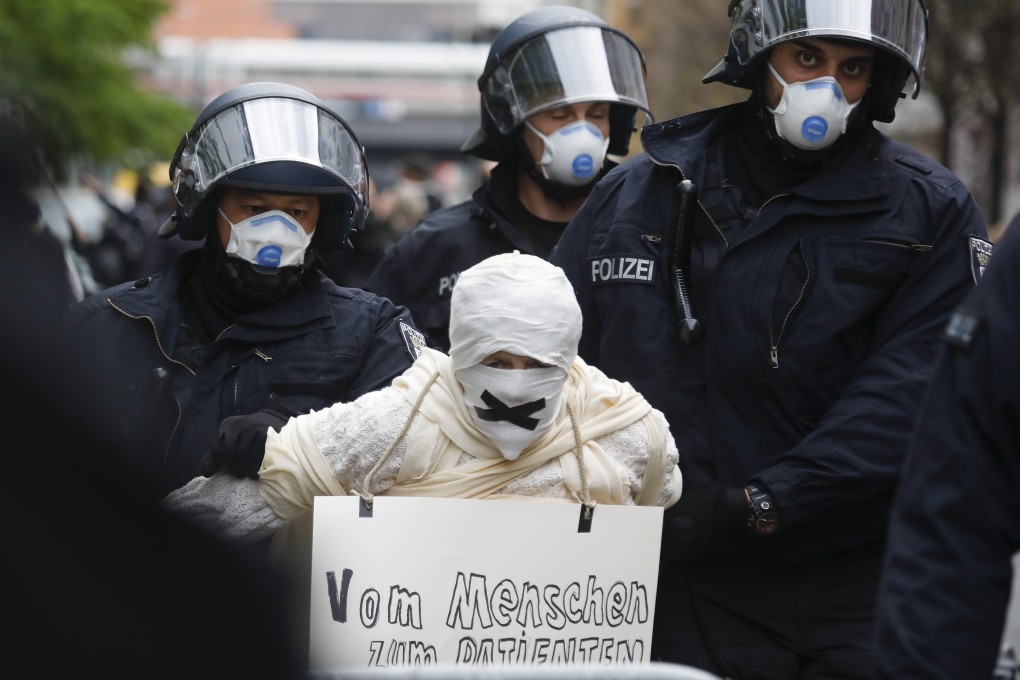 Police detain a person wrapped in bandages during an illegal demonstration in Berlin, Germany. Photo: AP
