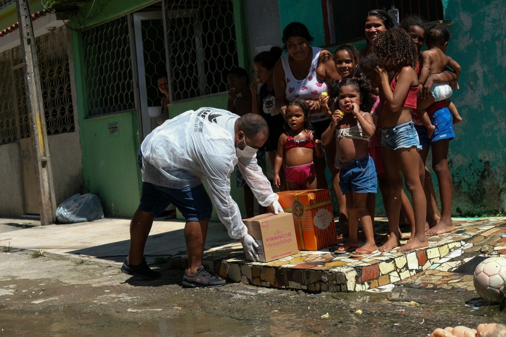 A volunteer delivers aid to poor families in the Vila Kennedy slum in Rio de Janeiro on April 2. The spread of Covid-19 and ensuing lockdowns have disproportionately affected the poor. Photo: Reuters